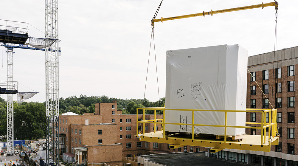 Prefabricated bathroom pods are lifted into the building using a crane to complete installation.