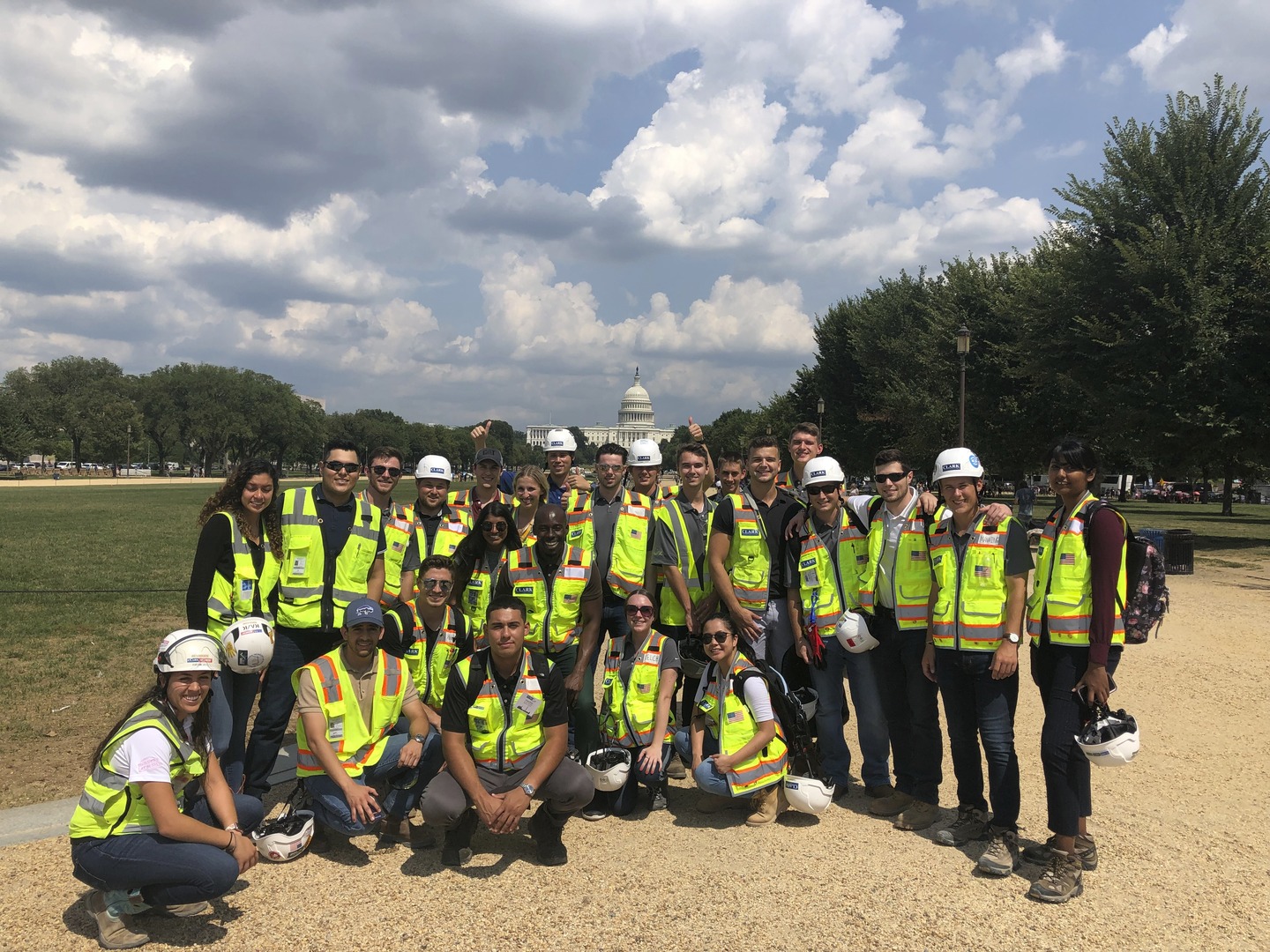 A group of Clark Summer Associates wear personal protective equipment (PPE) stand in front of the US Capitol Building on the National Mall