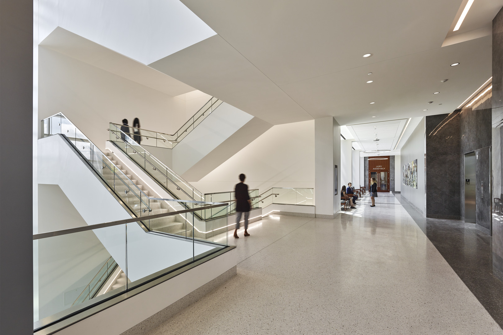 People walk the halls and stairs of the Howard County Courthouse built by Clark Construction