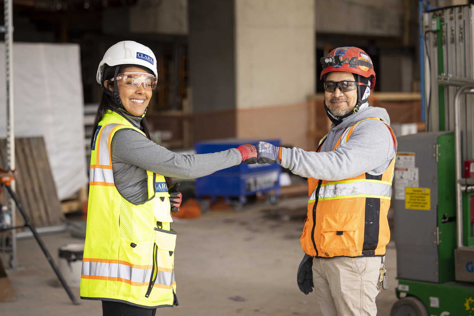 Dayan Escobar (left), a project engineer with Clark Construction, is passionate about her work and is seen here doing a fist bump for safety.