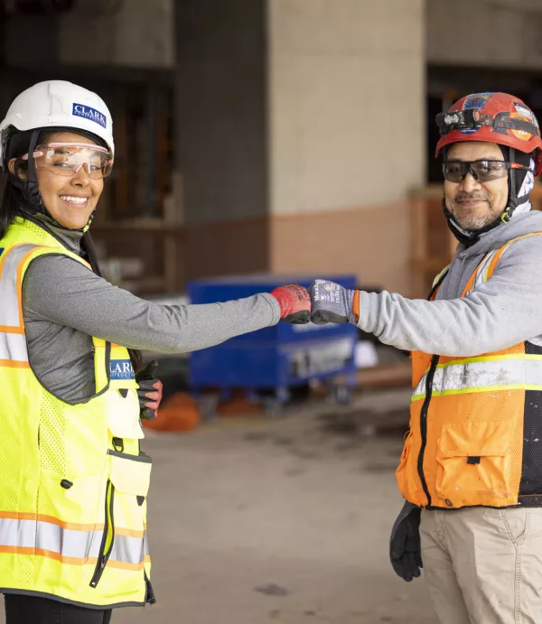 Dayan Escobar (left), a project engineer with Clark Construction, is passionate about her work and is seen here doing a fist bump for safety.