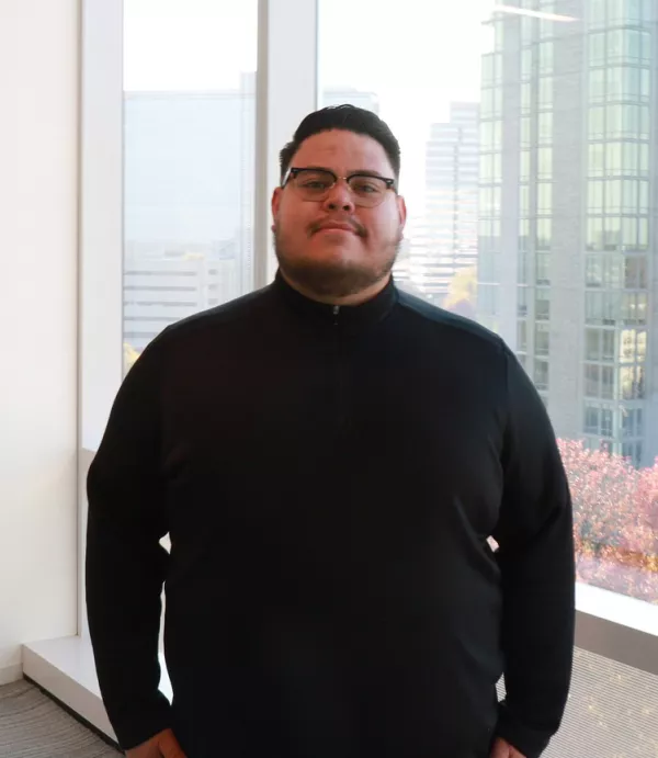 Tony Perez stands in front of a window in Clark Construction Group's office