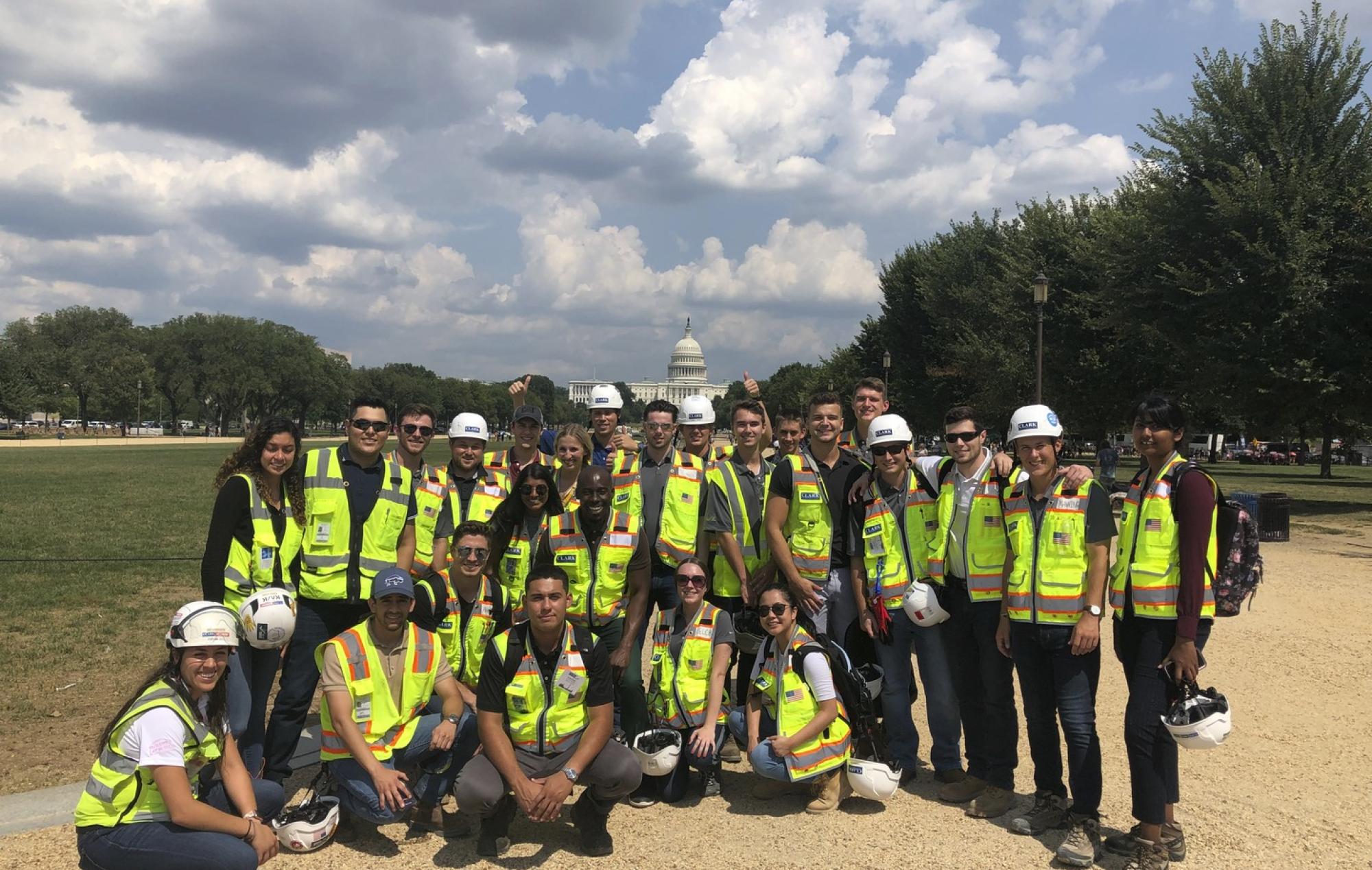 A group of Clark Summer Associates wear personal protective equipment (PPE) stand in front of the US Capitol Building on the National Mall